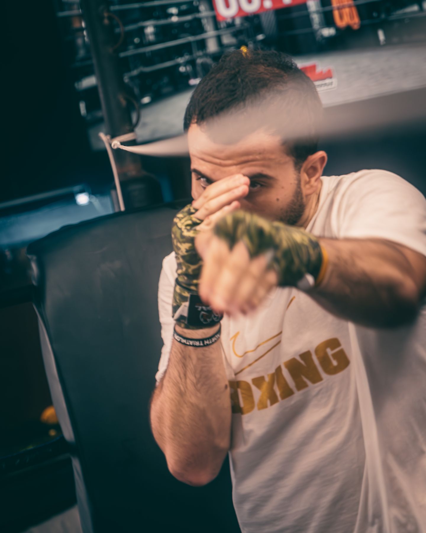 Boxer wrapping his hands and looking at the camera